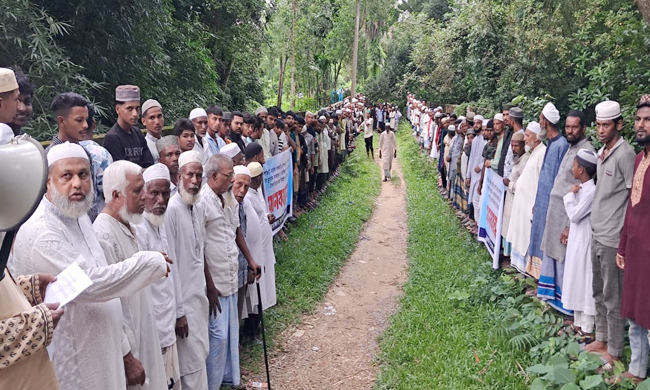 সরকারি জায়গা উদ্ধার না করে কবরস্থানের ওপর দিয়ে রাস্তা নির্মাণের প্রতিবাদে মানববন্ধন